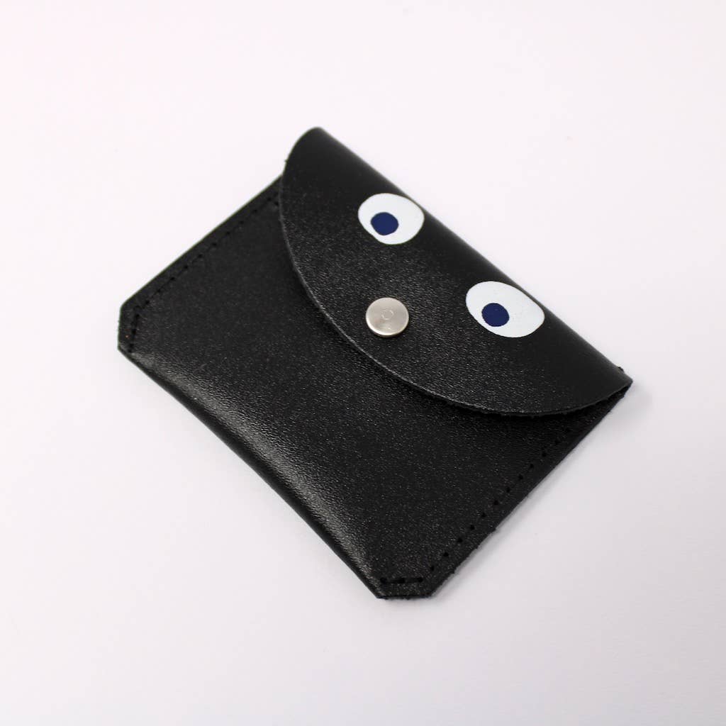 Black leather pouch with googly eyes on a white background