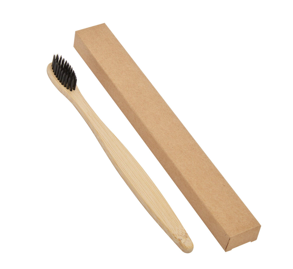 Bamboo toothbrush with black bristles and cardboard packaging on a white background
