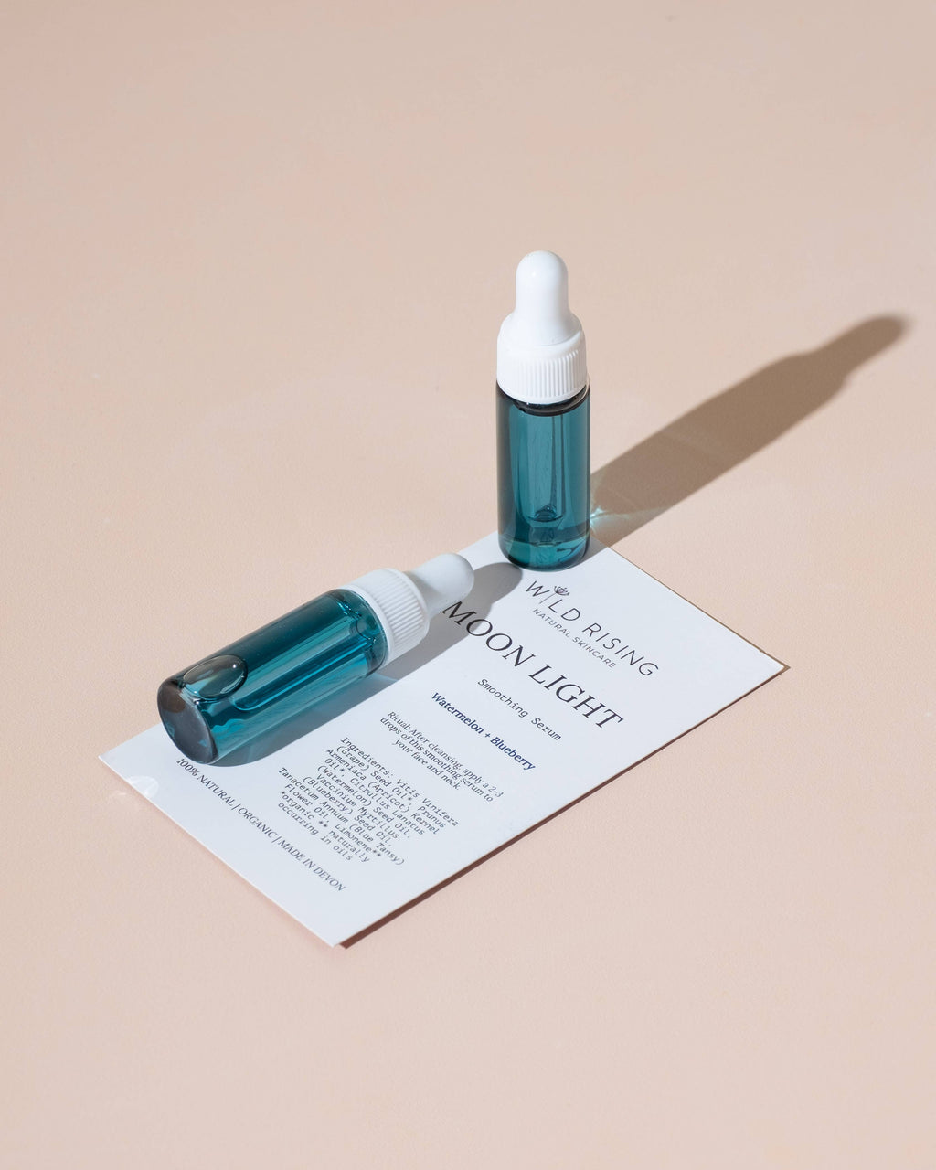 Two blue dropper bottles labeled 'Moon Light' on a beige background